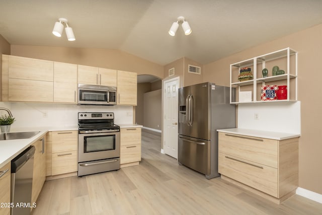 12044 S 45th St, Phoenix, AZ 85044 - kitchen with stainless steel appliances, light brown cabinets, lofted ceiling, light wood finished floors, and decorative backsplash