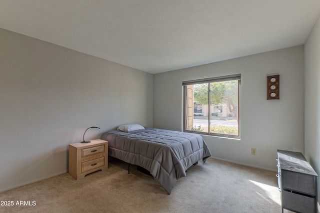 bedroom featuring light colored carpet and baseboards