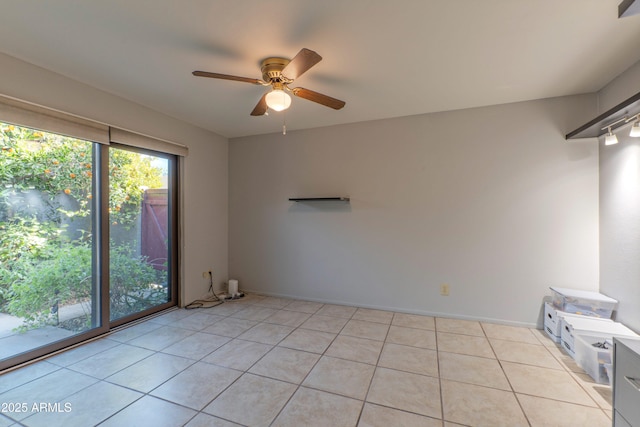 unfurnished room with ceiling fan, light tile patterned flooring, and baseboards