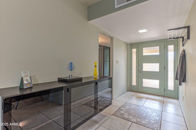 foyer entrance with a healthy amount of sunlight, visible vents, baseboards, and light tile patterned floors