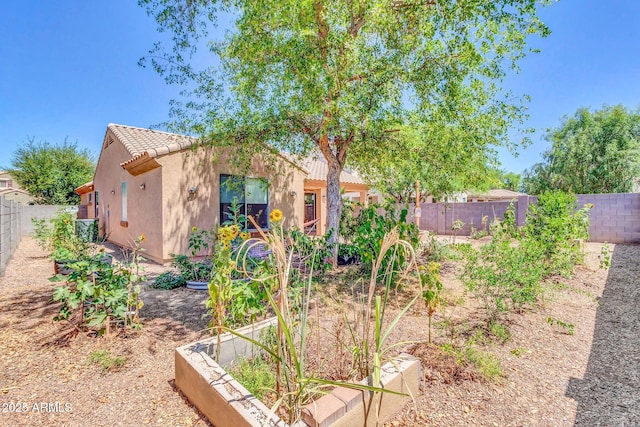4323 S Ranger Trl, Gilbert, AZ 85297 - view of front of home featuring a tiled roof, stucco siding, a fenced backyard, and a garden