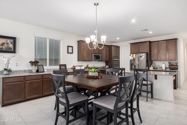 dining room with an inviting chandelier and light tile patterned floors