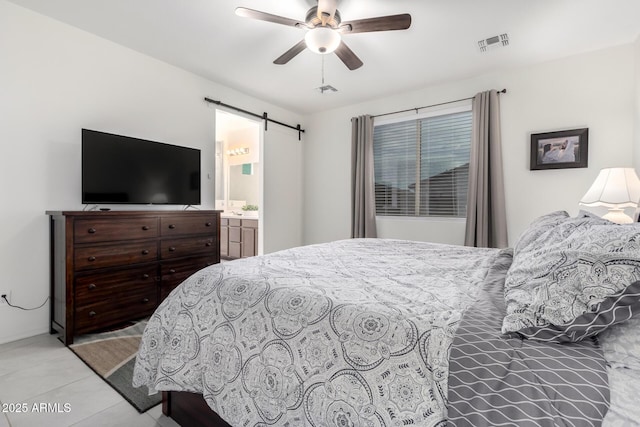 tiled bedroom with a barn door and ceiling fan