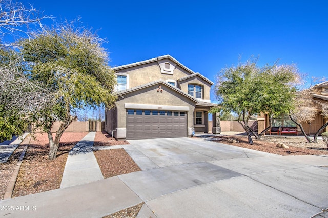 traditional-style home featuring concrete driveway, fence, a garage, and stucco siding