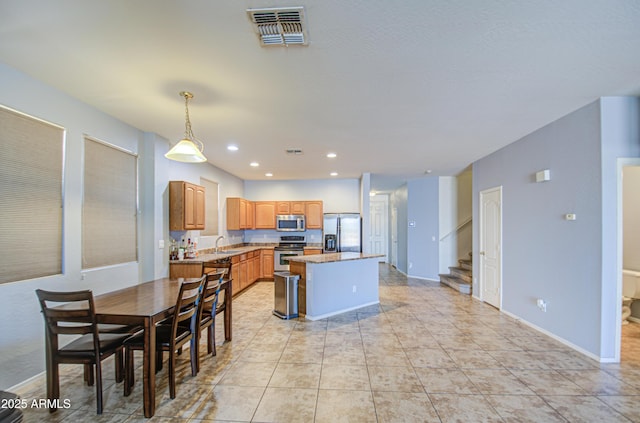 kitchen featuring visible vents, a kitchen island, recessed lighting, appliances with stainless steel finishes, and decorative light fixtures