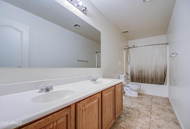 bathroom featuring double vanity, visible vents, toilet, and a sink