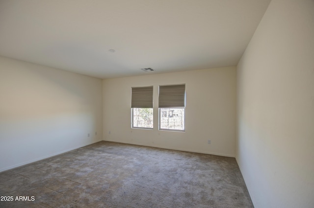 carpeted empty room featuring visible vents