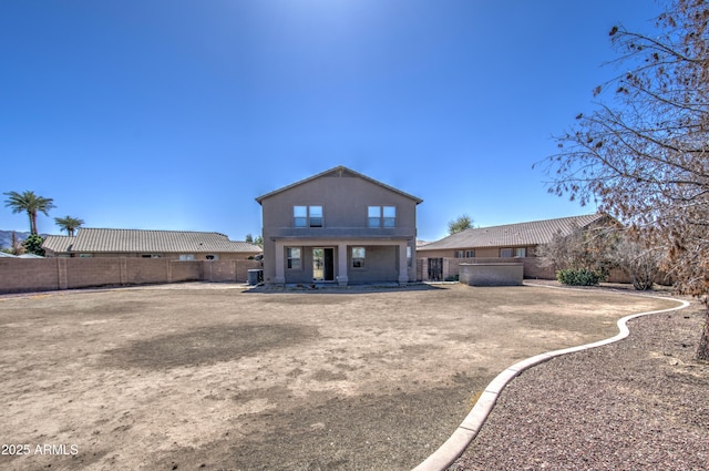 rear view of property with stucco siding and a fenced backyard