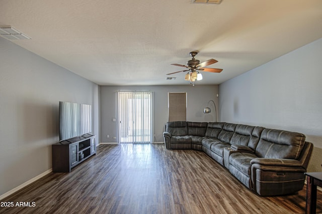 living area with visible vents, ceiling fan, dark wood-type flooring, and baseboards