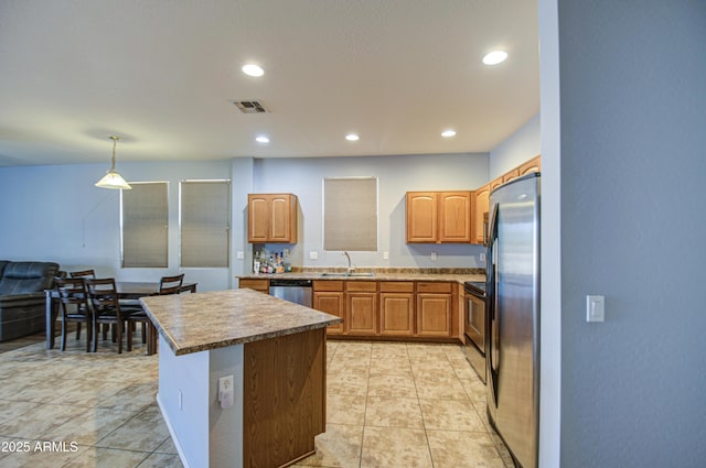 kitchen featuring visible vents, a sink, a center island, recessed lighting, and stainless steel appliances