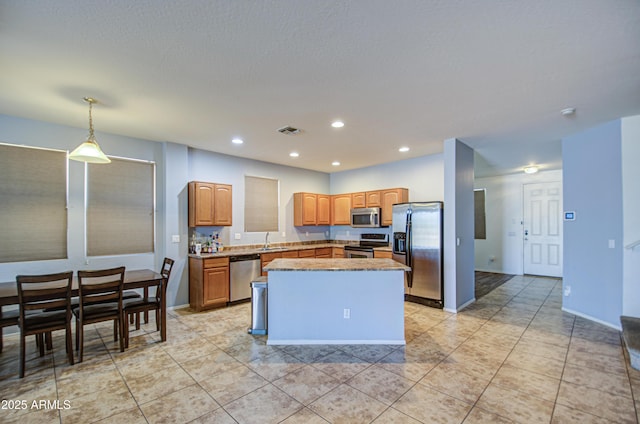 kitchen with visible vents, a sink, a center island, recessed lighting, and appliances with stainless steel finishes