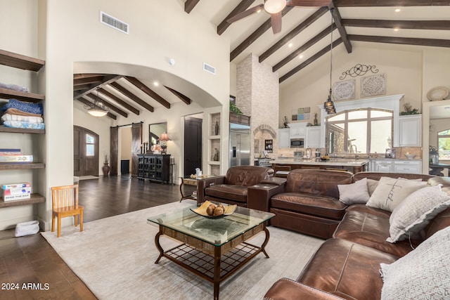 living room with ceiling fan, beam ceiling, hardwood / wood-style floors, and high vaulted ceiling