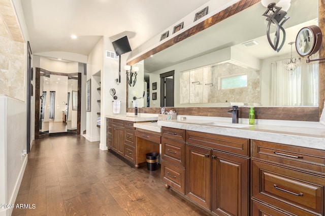 bathroom featuring a notable chandelier, vanity, a shower, and hardwood / wood-style floors