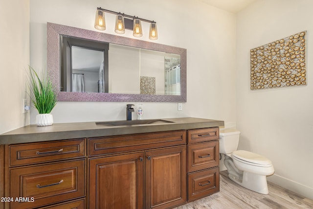 bathroom featuring wood-type flooring, vanity, and toilet