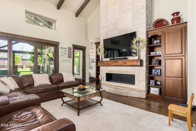 living room featuring light hardwood / wood-style floors, high vaulted ceiling, beamed ceiling, and a stone fireplace