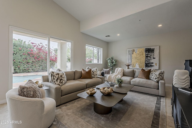 living room featuring baseboards, lofted ceiling, visible vents, and recessed lighting