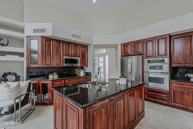 kitchen featuring a sink, stainless steel appliances, light tile patterned floors, visible vents, and decorative backsplash