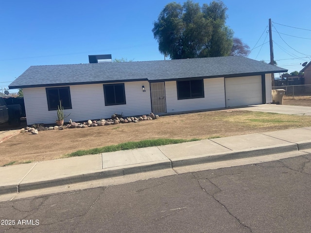 715 E Roosevelt Ave, Buckeye, AZ 85326 - ranch-style home featuring driveway, an attached garage, roof with shingles, and a front lawn