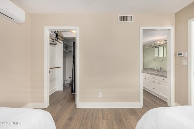 12821 N 67th St, Scottsdale, AZ 85254 - bedroom with an AC wall unit, a spacious closet, wood finished floors, and baseboards