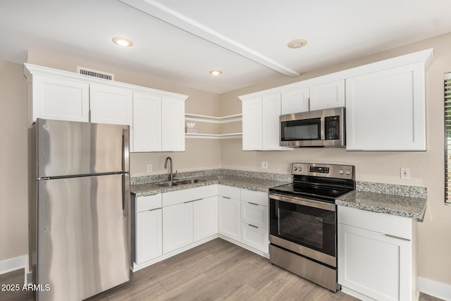 12821 N 67th St, Scottsdale, AZ 85254 - kitchen with appliances with stainless steel finishes, a sink, white cabinetry, light wood finished floors, and light stone counters