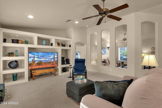 living room featuring light carpet, vaulted ceiling, built in shelves, and ceiling fan