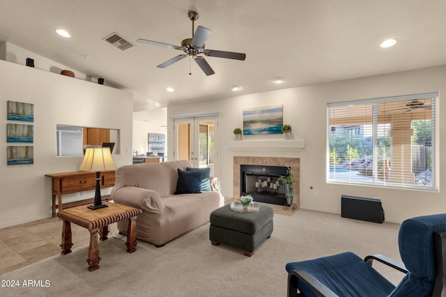 carpeted living room with a fireplace, vaulted ceiling, and ceiling fan