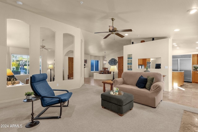 carpeted living room featuring ceiling fan and vaulted ceiling