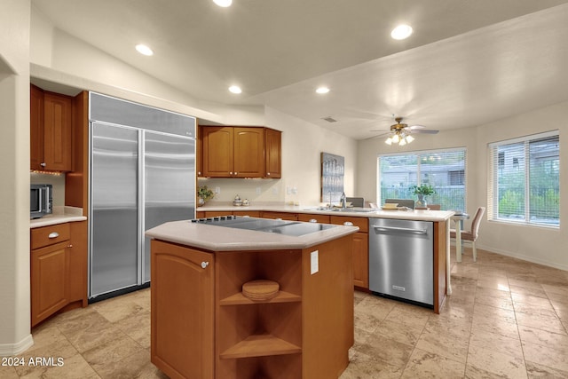 kitchen featuring stainless steel appliances, kitchen peninsula, sink, a kitchen island, and ceiling fan