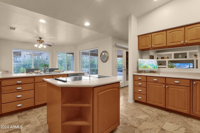 kitchen with a kitchen island, ceiling fan, sink, and black electric stovetop