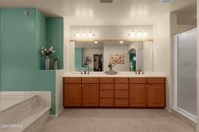 bathroom with vanity, a textured ceiling, and an enclosed shower