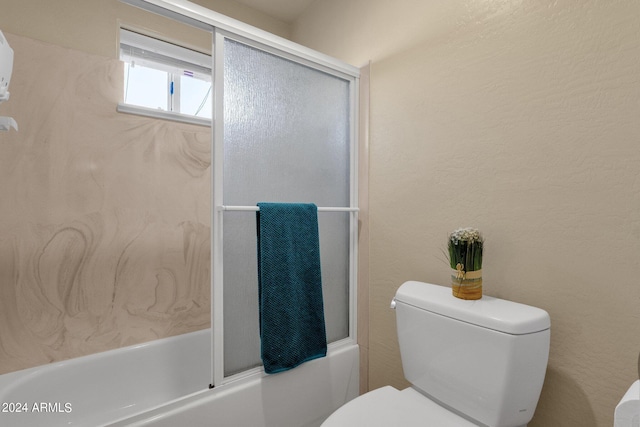 bathroom featuring shower / bath combination with glass door and toilet