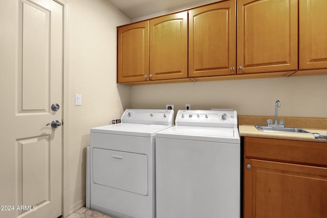 washroom featuring cabinets, sink, and washing machine and dryer