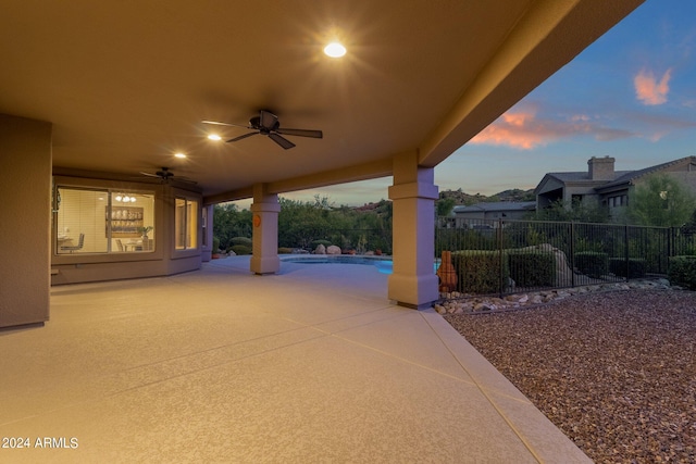 patio terrace at dusk featuring ceiling fan