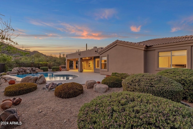 pool at dusk featuring a patio