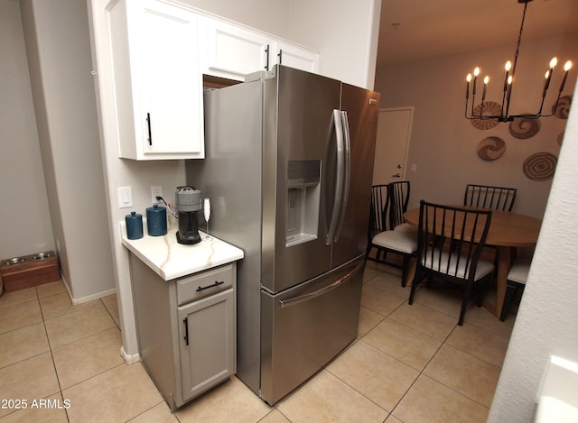 kitchen with stainless steel refrigerator with ice dispenser, white cabinets, and light tile patterned floors