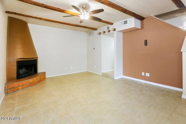 unfurnished living room featuring a fireplace, beamed ceiling, tile patterned floors, and ceiling fan