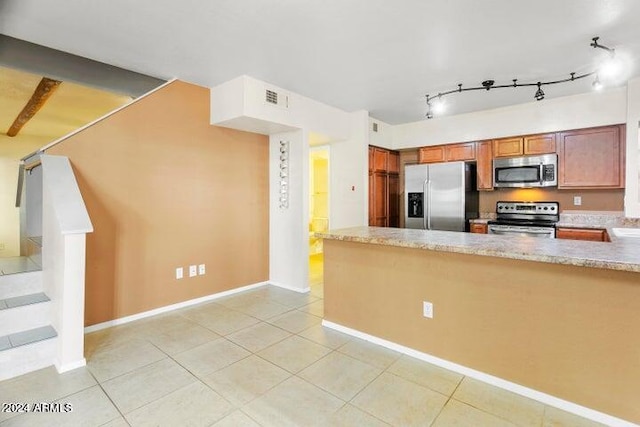 kitchen with stainless steel appliances, light tile patterned flooring, beamed ceiling, and rail lighting