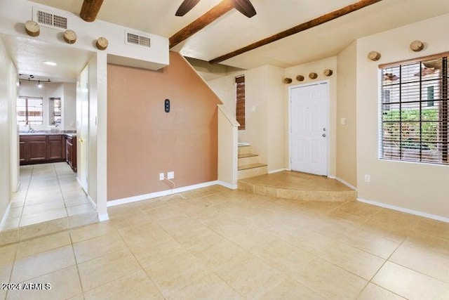 tiled foyer entrance featuring beamed ceiling and a wealth of natural light