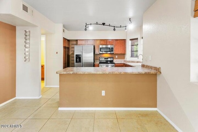 kitchen featuring kitchen peninsula, sink, light tile patterned floors, and stainless steel appliances