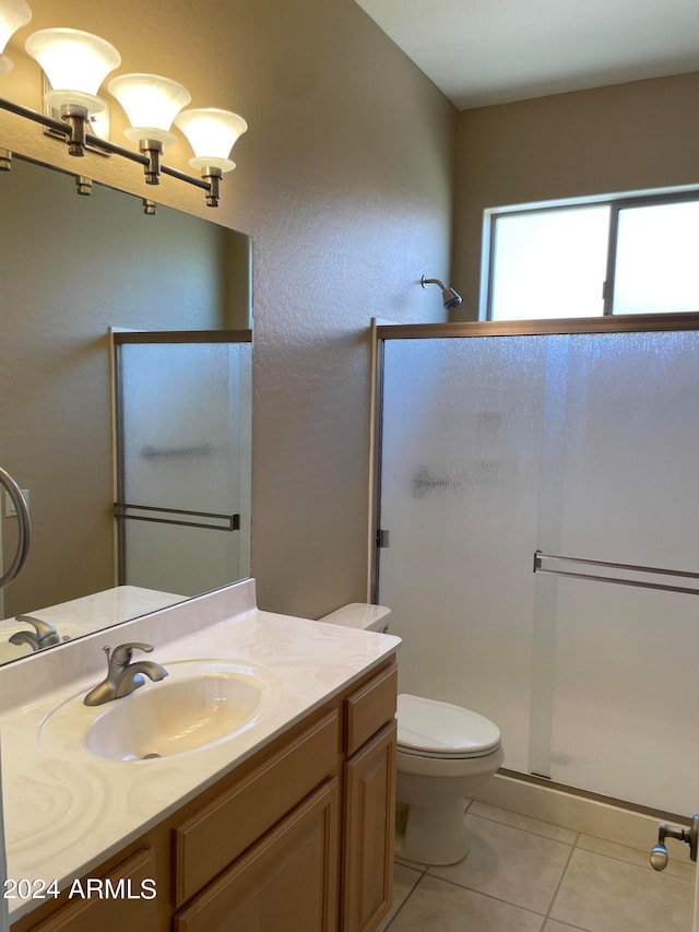 bathroom with walk in shower, toilet, tile floors, and vanity