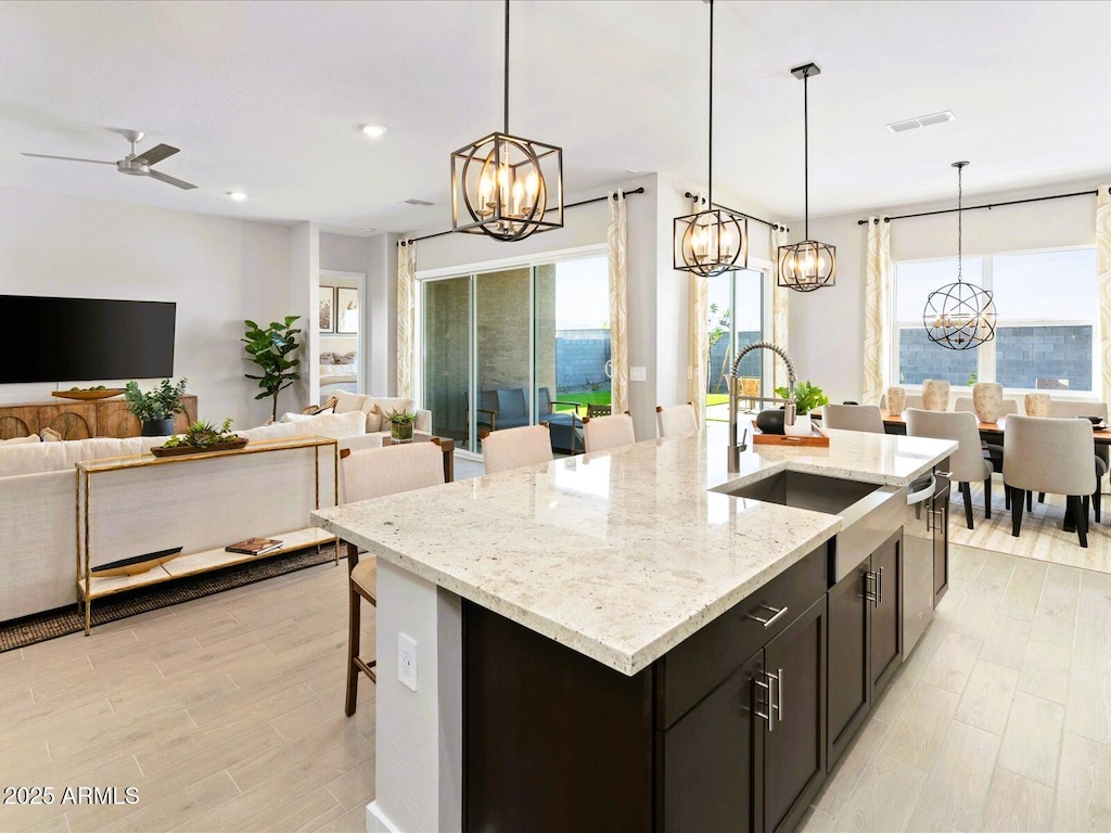 17633 W Pierson St, Goodyear, AZ 85395 - kitchen featuring visible vents, a center island with sink, a sink, open floor plan, and a breakfast bar area