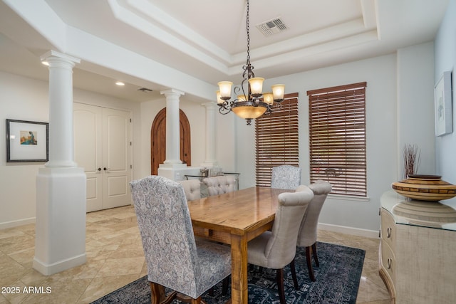 dining area featuring decorative columns, visible vents, a raised ceiling, and baseboards