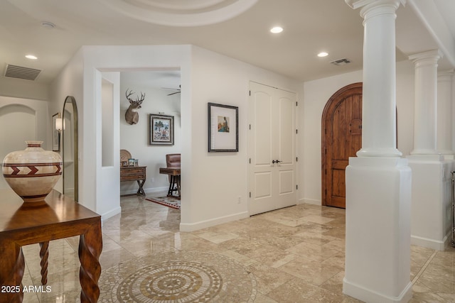 corridor featuring arched walkways, recessed lighting, visible vents, and ornate columns