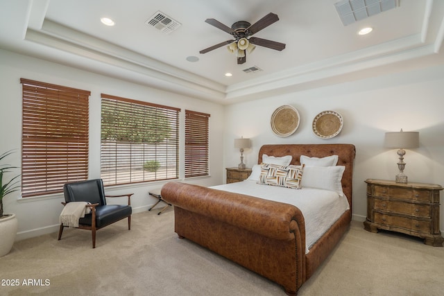 carpeted bedroom with a tray ceiling, visible vents, and baseboards