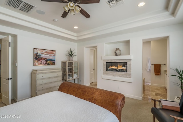 bedroom with recessed lighting, visible vents, a tray ceiling, and light colored carpet