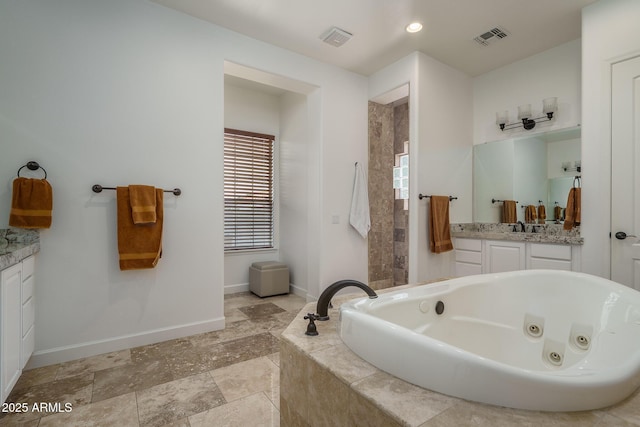 bathroom featuring a jetted tub, baseboards, visible vents, and vanity