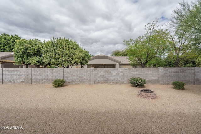 view of yard featuring a fire pit and fence