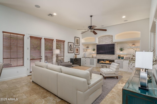 living area with ceiling fan, recessed lighting, visible vents, baseboards, and a tiled fireplace