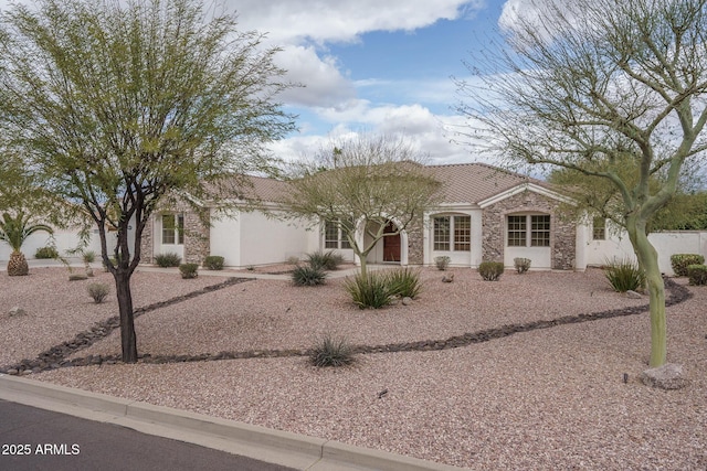 view of front of house featuring stone siding, a tiled roof, and stucco siding