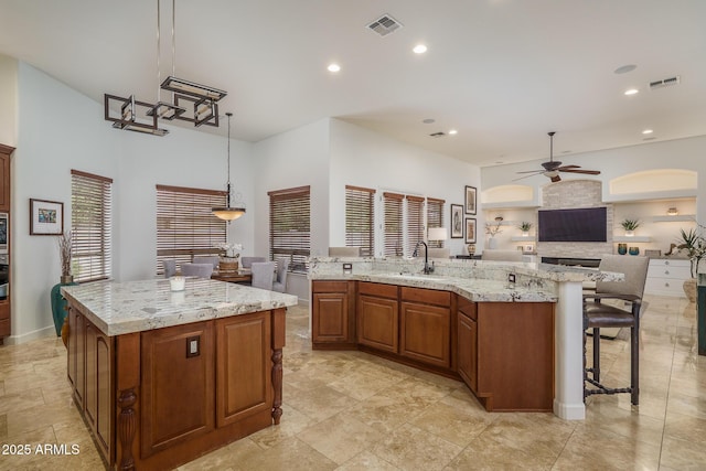 kitchen with a kitchen island, visible vents, and brown cabinetry